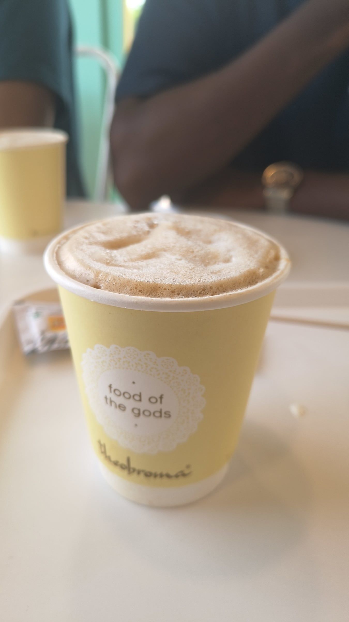 A cup of coffee with foam on a café table