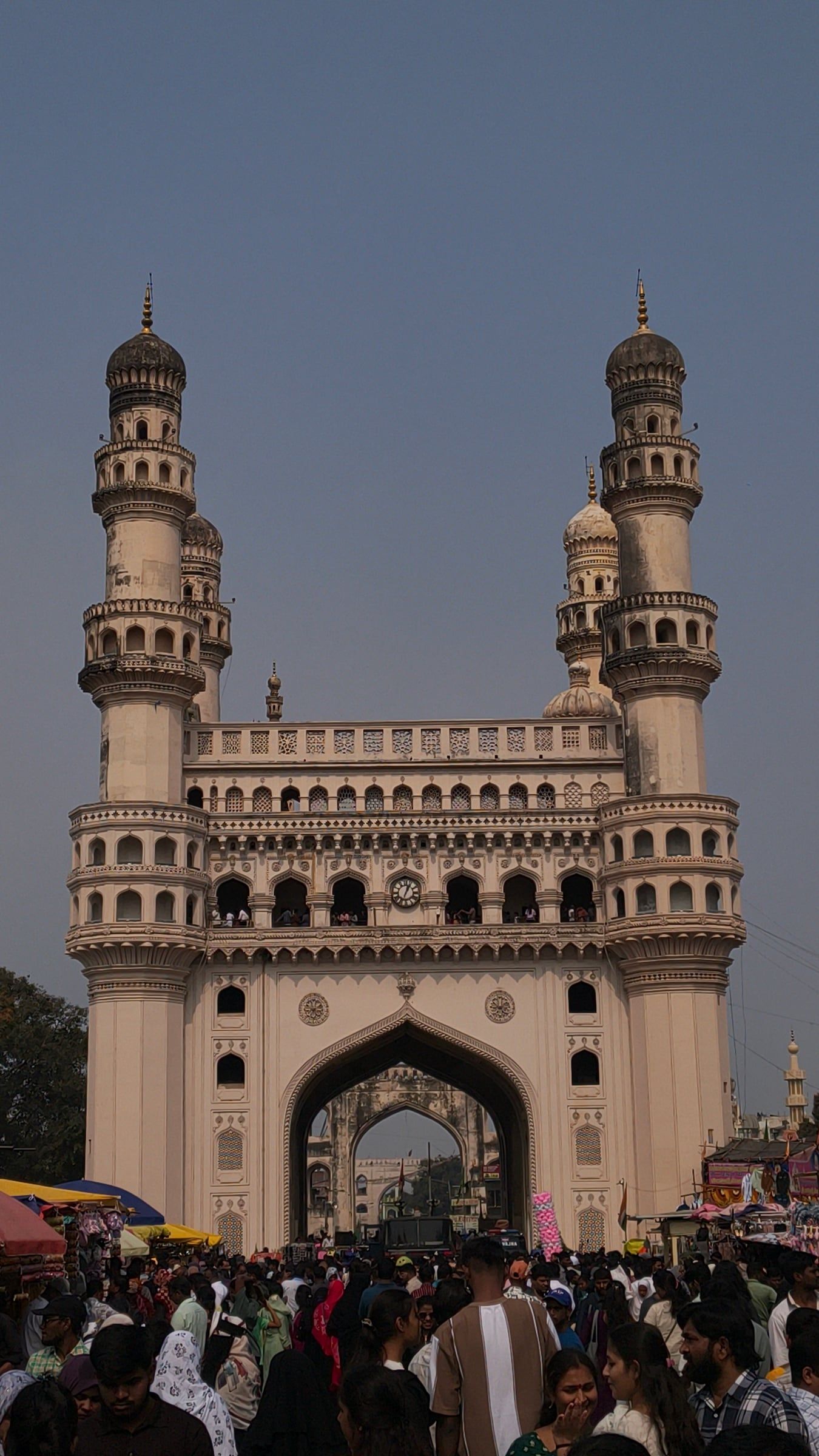 Charminar at dusk above a busy street crowd