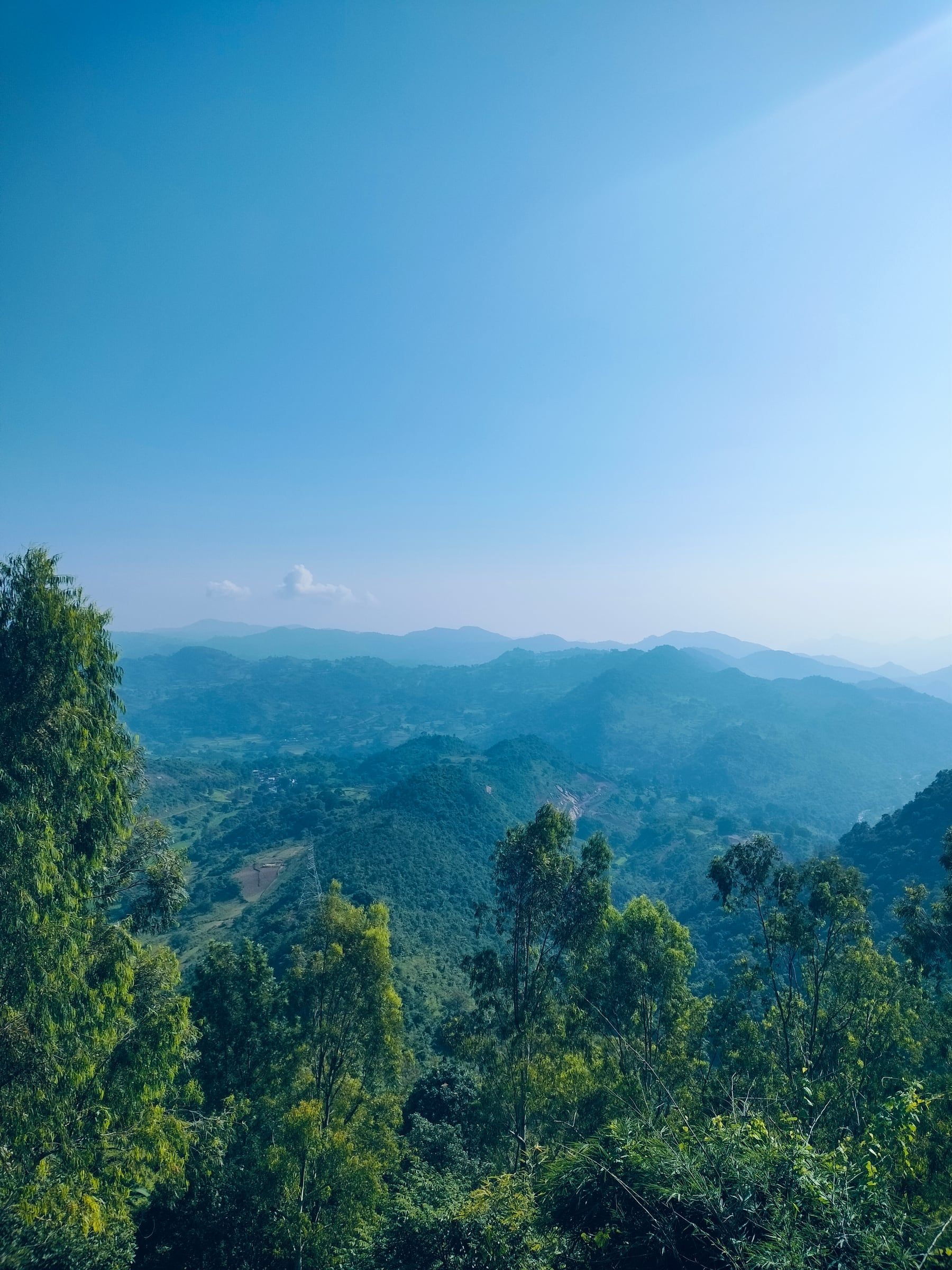 Layers of green hills under a clear morning sky